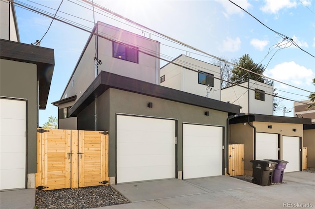 1747 Lowell Blvd, Denver, CO 80204 - view of home's exterior with a garage, a gate, stucco siding, and driveway