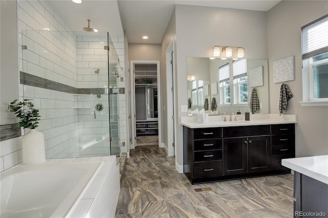 bathroom featuring vanity and shower with separate bathtub