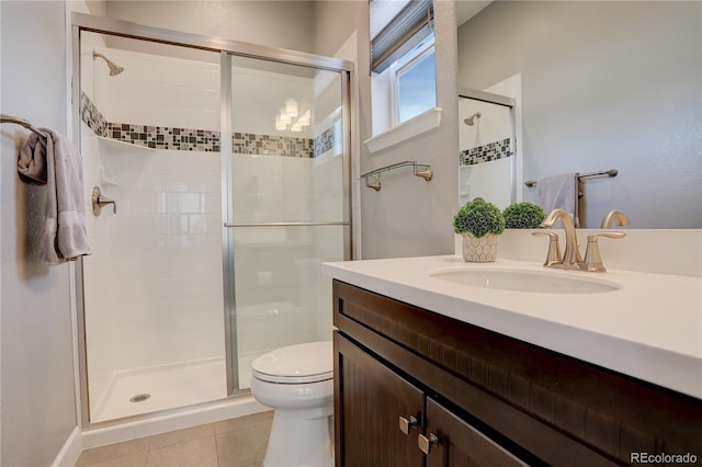 bathroom featuring toilet, vanity, tile patterned floors, and an enclosed shower