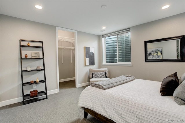 carpeted bedroom featuring a walk in closet and a closet