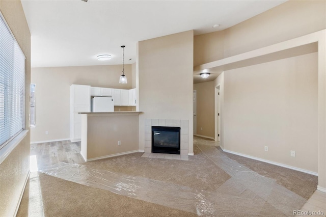 unfurnished living room featuring a fireplace and high vaulted ceiling