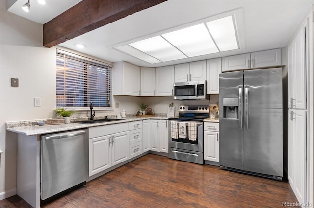 kitchen featuring dark wood-style flooring, a sink, white cabinets, appliances with stainless steel finishes, and beamed ceiling