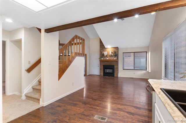 kitchen featuring visible vents, dark wood-type flooring, lofted ceiling with beams, stainless steel dishwasher, and white cabinetry