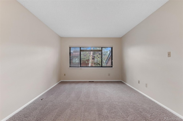 unfurnished room with light colored carpet and baseboards