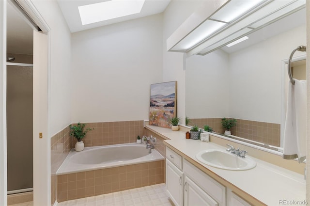 bathroom with vanity, a skylight, a bath, and a stall shower