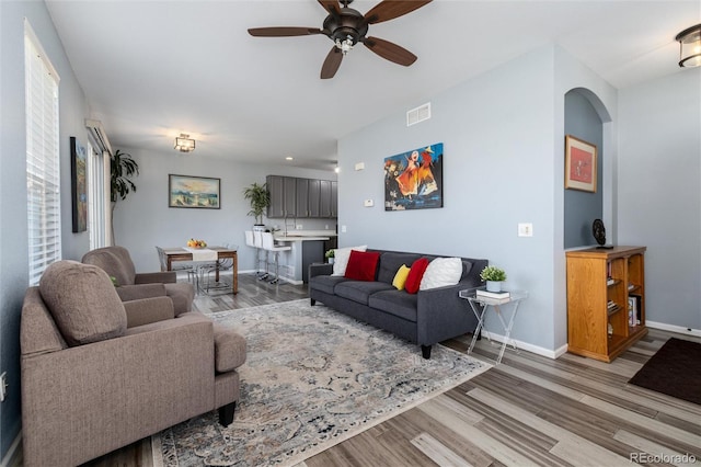 4797 Flower St, Wheat Ridge, CO 80033 - living room featuring light wood finished floors, ceiling fan, baseboards, and arched walkways