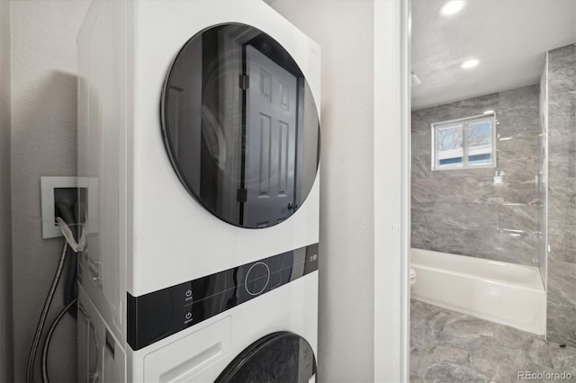 clothes washing area with stacked washer and dryer