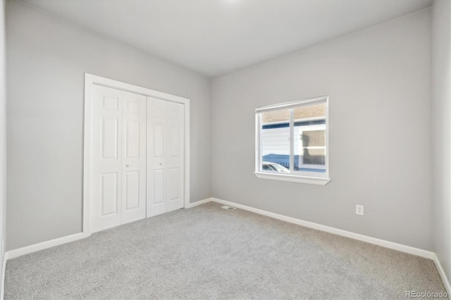 unfurnished bedroom with carpet and a closet