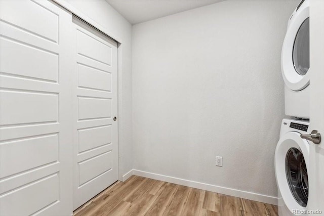 485 Interlocken Blvd Unit 106, Broomfield, CO 80021 - washroom featuring stacked washer / drying machine, light wood finished floors, and baseboards