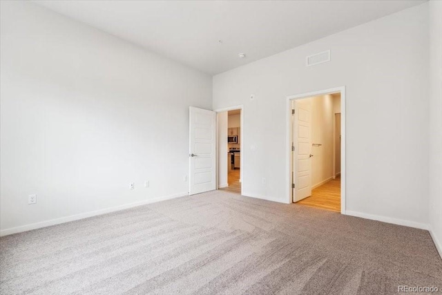 485 Interlocken Blvd Unit 106, Broomfield, CO 80021 - unfurnished bedroom featuring light carpet, baseboards, and connected bathroom