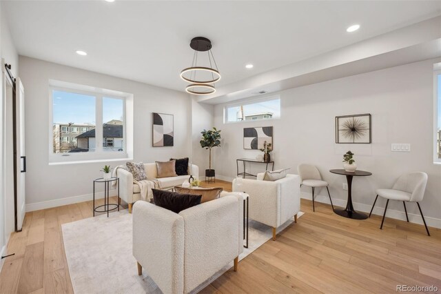 living area with light wood-style floors, baseboards, and recessed lighting