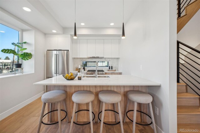 kitchen with tasteful backsplash, high end fridge, recessed lighting, baseboards, and modern cabinets