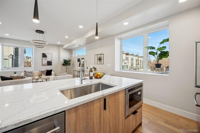 kitchen with dishwasher, modern cabinets, open floor plan, and a sink