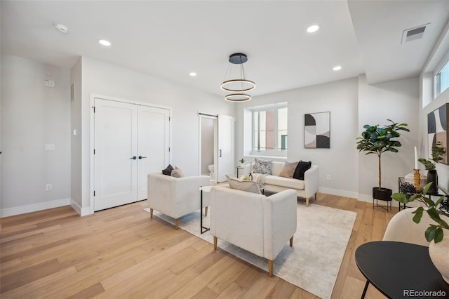 living room featuring visible vents, light wood-style flooring, baseboards, and recessed lighting