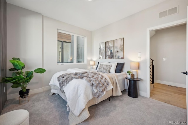 carpeted bedroom featuring baseboards and visible vents
