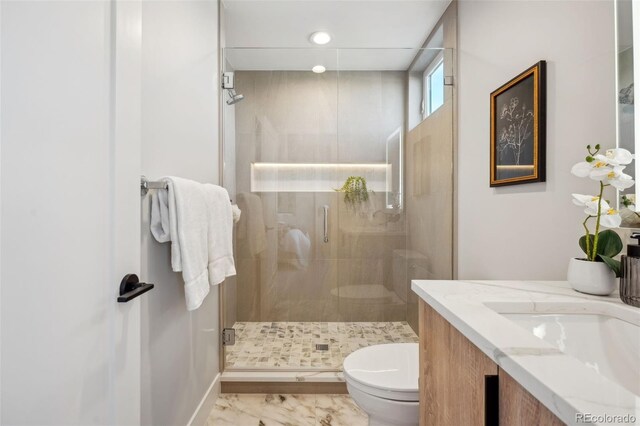bathroom with toilet, marble finish floor, baseboards, and a stall shower