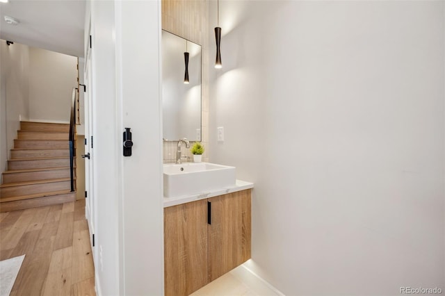 bathroom with baseboards, wood finished floors, and vanity