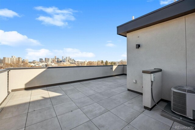 view of patio / terrace with cooling unit and a view of city