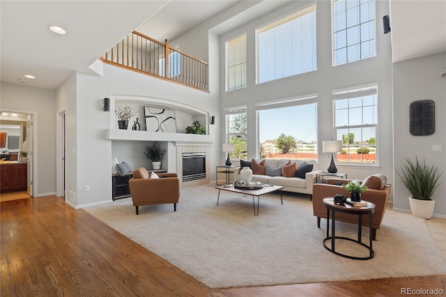 1461 S Grand Baker St, Aurora, CO 80018 - living room with wood finished floors, a high ceiling, a tiled fireplace, and recessed lighting