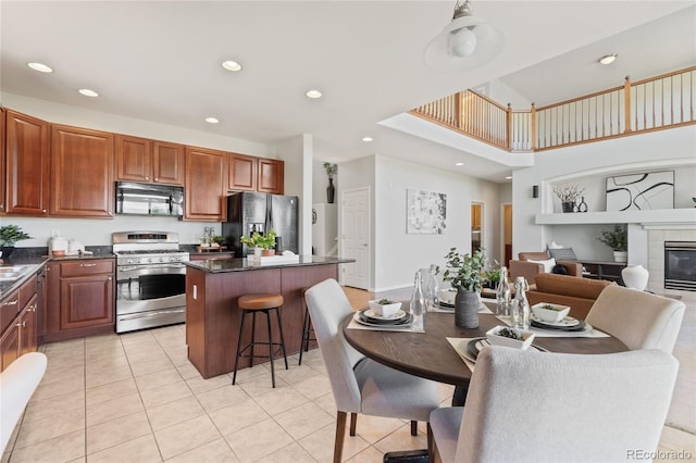 1461 S Grand Baker St, Aurora, CO 80018 - dining room with recessed lighting, light tile patterned floors, a tiled fireplace, and a high ceiling