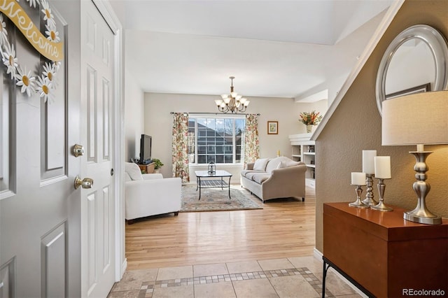 living room with light tile patterned floors, a chandelier, and baseboards