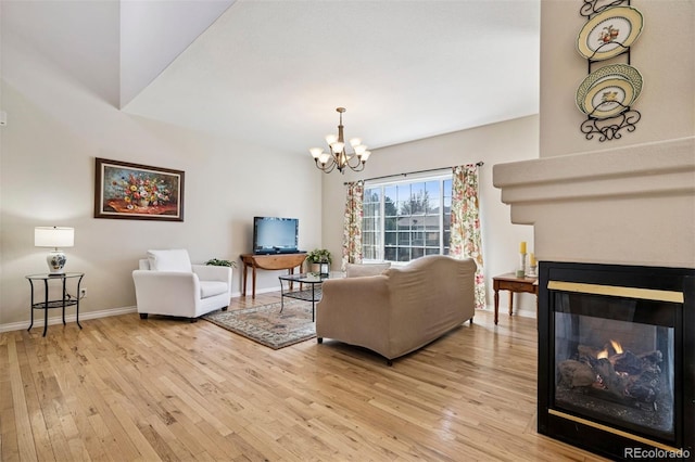 living area featuring light wood-style floors, a chandelier, a multi sided fireplace, and baseboards