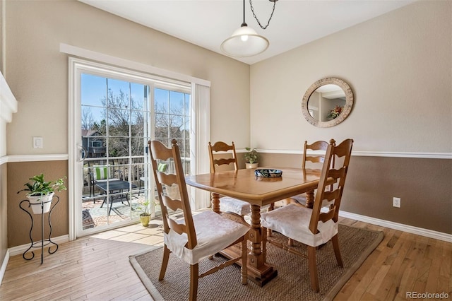 dining space with light wood-style floors and baseboards