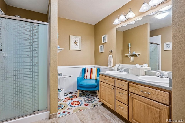 bathroom featuring a stall shower, double vanity, and tile patterned floors