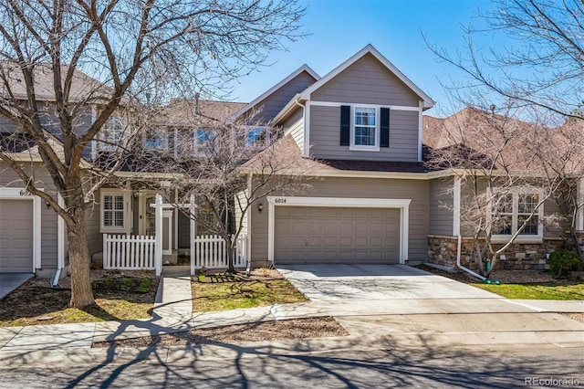 view of front facade with a garage, driveway, and fence
