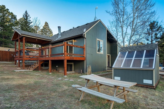 1011 S S, Woodland Park, CO 80863 - rear view of house featuring roof with shingles, a deck, stairway, and a yard