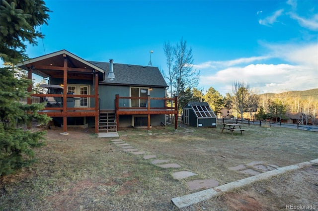 1011 S S, Woodland Park, CO 80863 - back of property featuring a storage shed, a wooden deck, an outbuilding, fence, and stairway