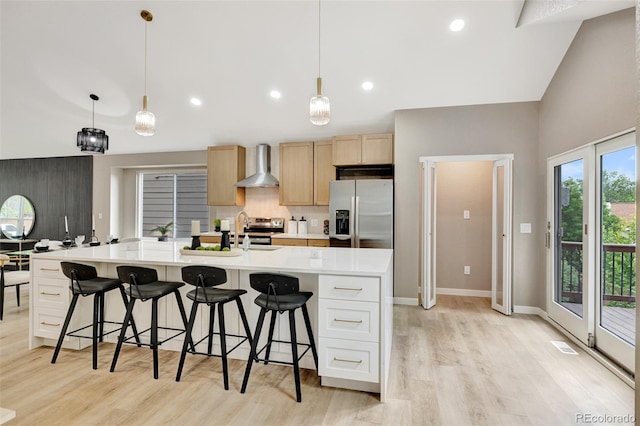 9371 Princeton Ln, Highlands Ranch, CO 80130 - kitchen with appliances with stainless steel finishes, wall chimney range hood, light wood-type flooring, light countertops, and light brown cabinets