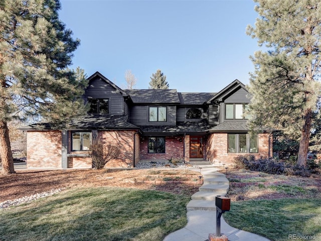 view of front of home featuring brick siding and a front lawn