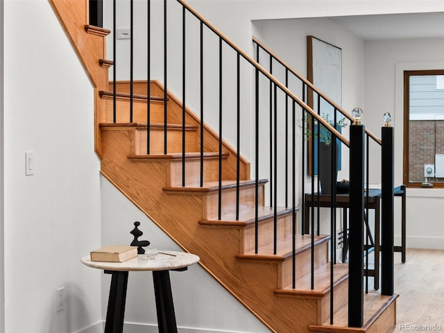 stairway with baseboards and wood finished floors