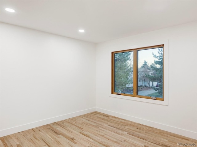 spare room with light wood-style floors, recessed lighting, and baseboards