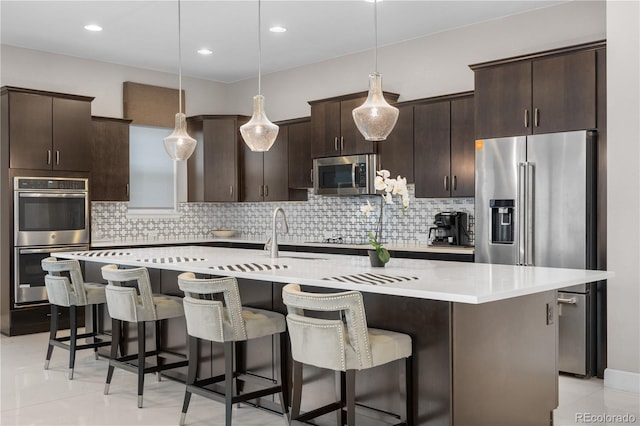 11193 Mission Walk St, Parker, CO 80134 - kitchen featuring appliances with stainless steel finishes, dark brown cabinetry, a breakfast bar area, light countertops, and recessed lighting
