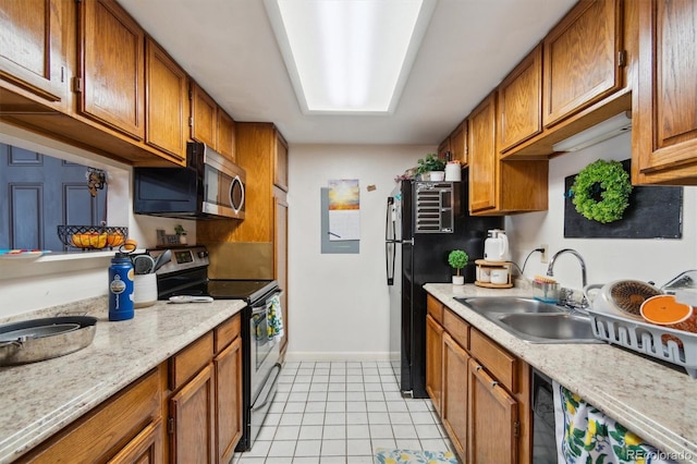 kitchen with black appliances, light stone counters, light tile patterned floors, and sink