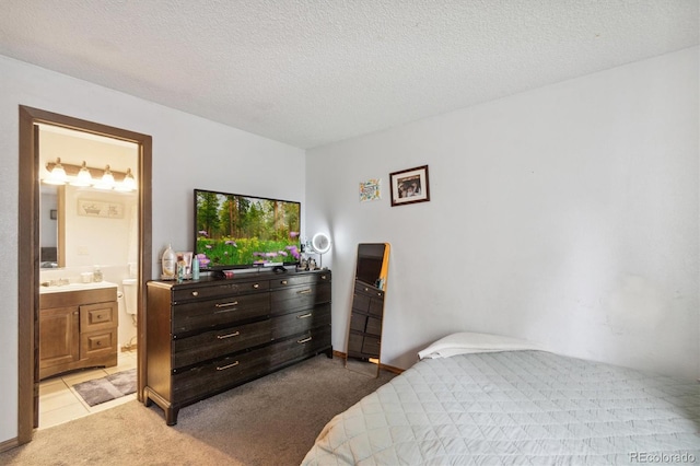 carpeted bedroom with a textured ceiling and ensuite bathroom