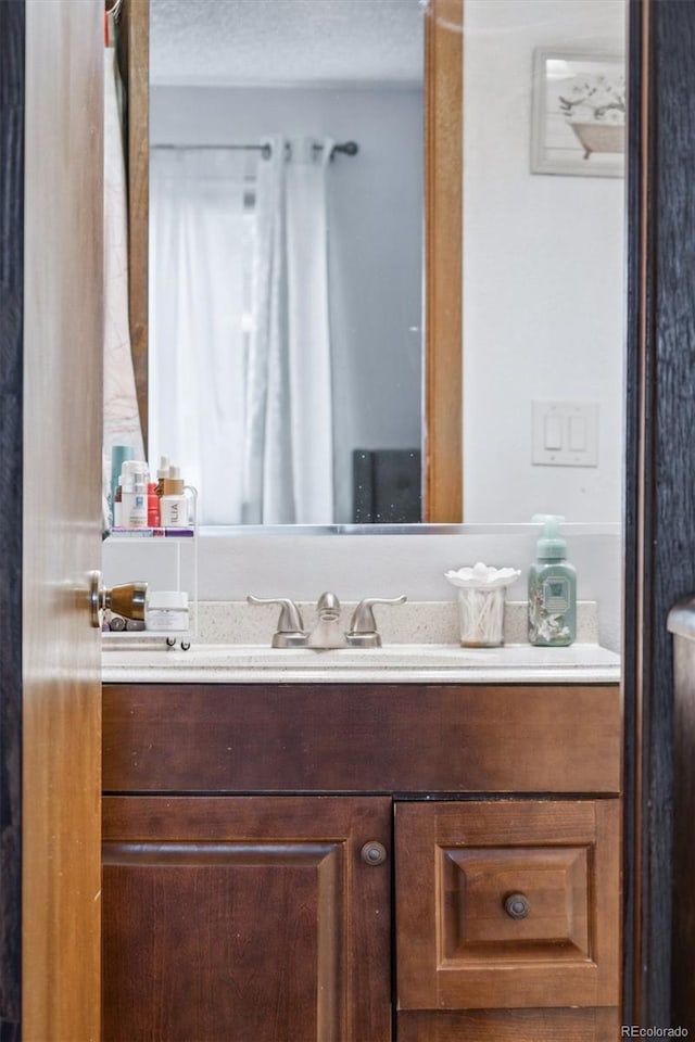 bathroom featuring a textured ceiling and vanity