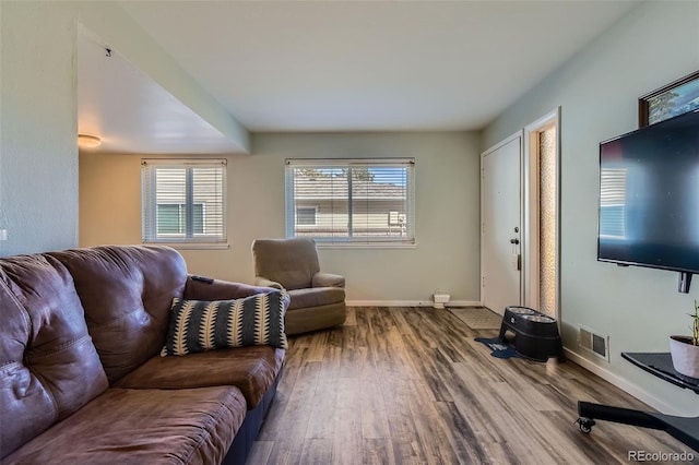 living area with visible vents, baseboards, and wood finished floors