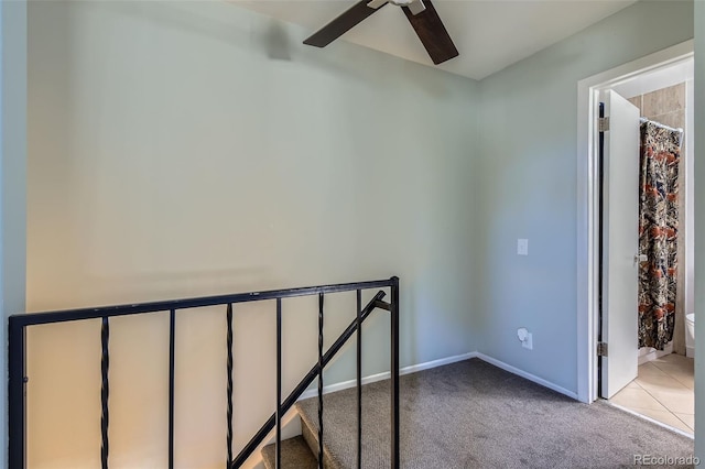 staircase featuring carpet, baseboards, and a ceiling fan