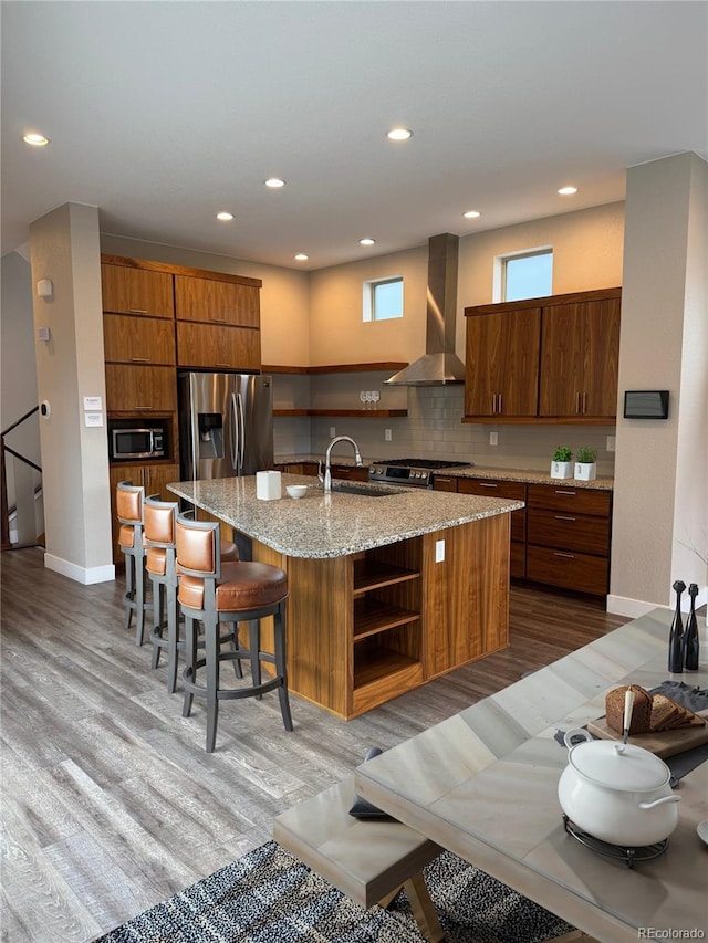 9715 Taylor River Cir, Littleton, CO 80125 - kitchen with wall chimney range hood, open shelves, appliances with stainless steel finishes, light wood-style flooring, and recessed lighting