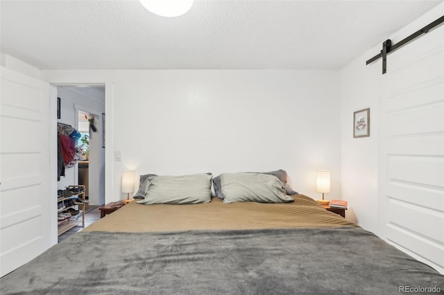 unfurnished bedroom with a textured ceiling and a barn door