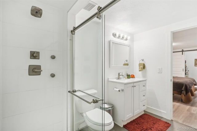 bathroom with toilet, vanity, and tiled shower