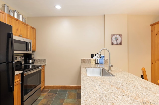 53 Hunki Dori Ct Unit 8886, Keystone, CO 80435 - kitchen with stainless steel appliances, a peninsula, recessed lighting, dark stone finish flooring, and light stone counters