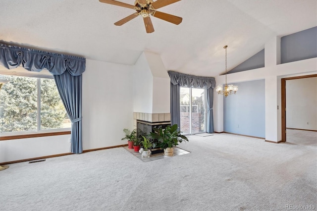 living area featuring a tiled fireplace, a healthy amount of sunlight, and carpet floors