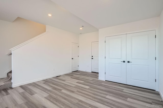 unfurnished bedroom with light hardwood / wood-style floors and a closet