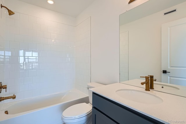 full bathroom featuring tiled shower / bath combo, toilet, and vanity