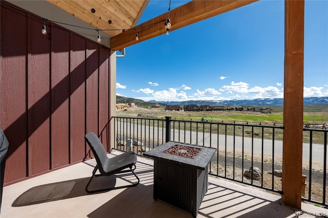 balcony featuring a mountain view and a fire pit