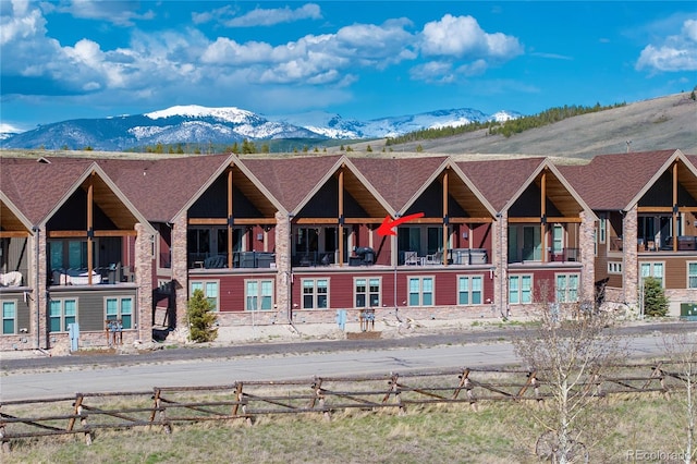 view of building exterior featuring a mountain view and fence